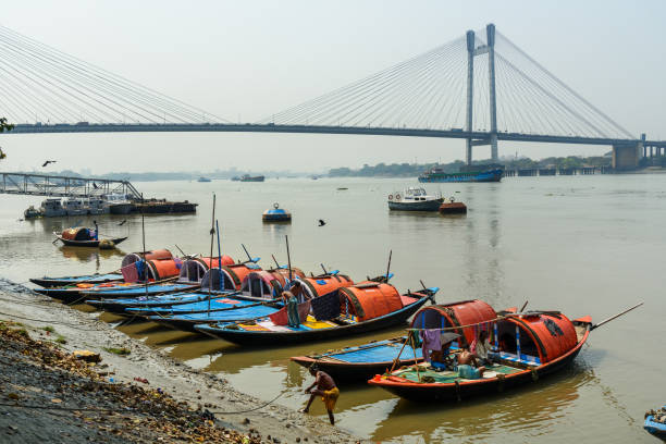 Kolkata, India - March 12, 2019: Traditional wooden fishing boats in river Hooghly or Ganga near Vidyasagar bridge